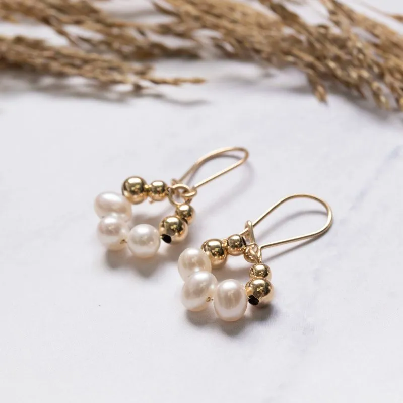 Yellow gold dangling earrings with pearl and gold beads